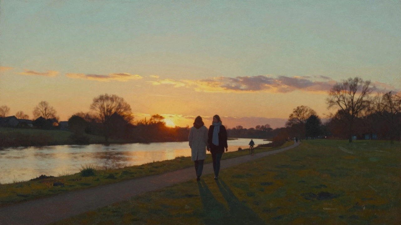 A couple walking peacefully at sunset along the River Lea, shadows long on the grass.