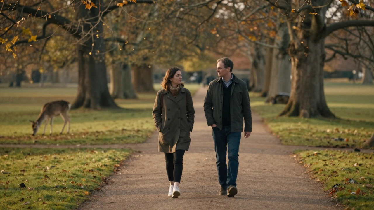 Two individuals strolling peacefully through Richmond Park in autumn sunlight.