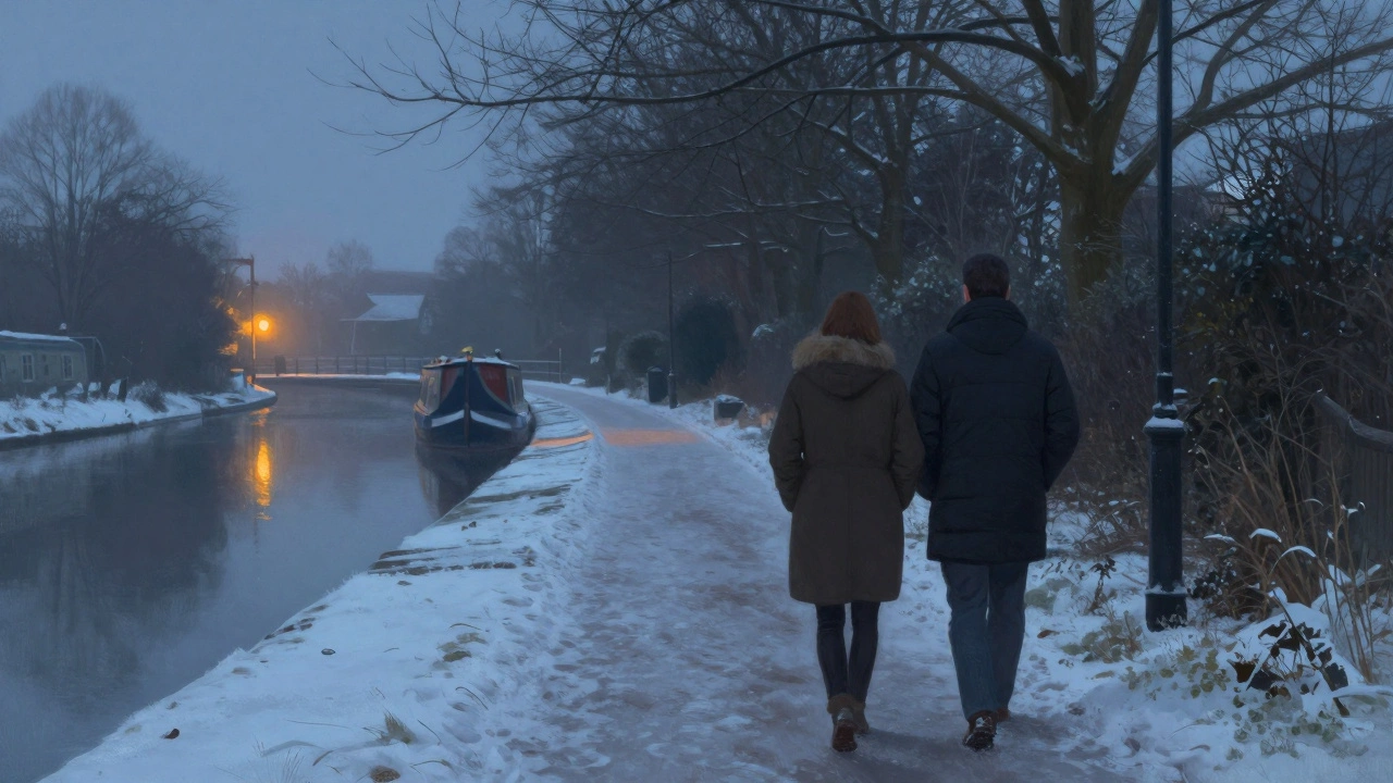 A couple walks silently along a snowy canal path in Ealing, surrounded by bare trees and distant pub lights.