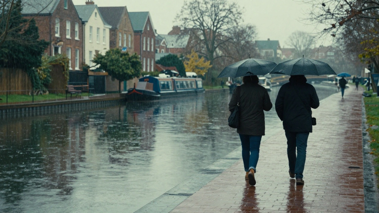 Two figures walking along Regent's Canal under umbrellas